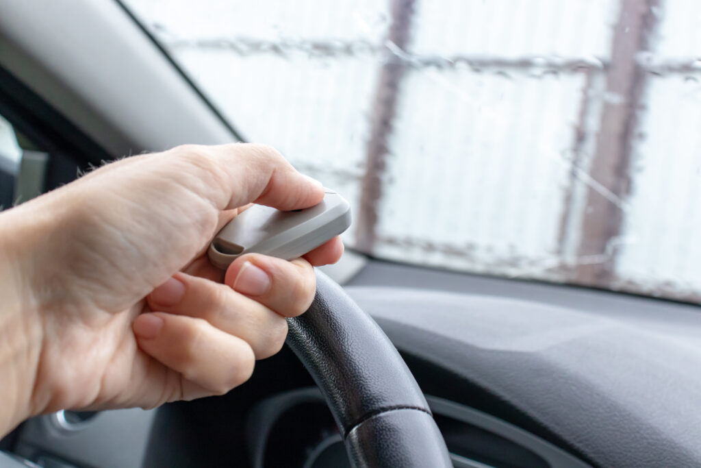 how to program liftmaster garage door opener Woman hand inside the car, driver using remote control to open the automatic gate while leaving home, security system and save time concept.