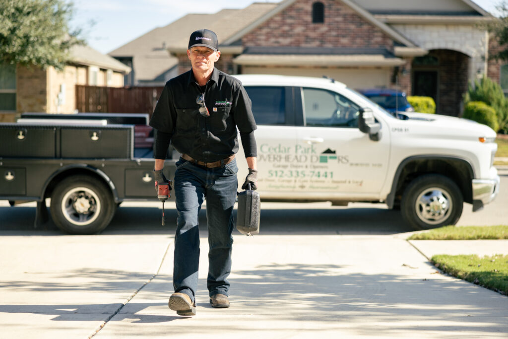 garage door tune up worker walking behind branded truck