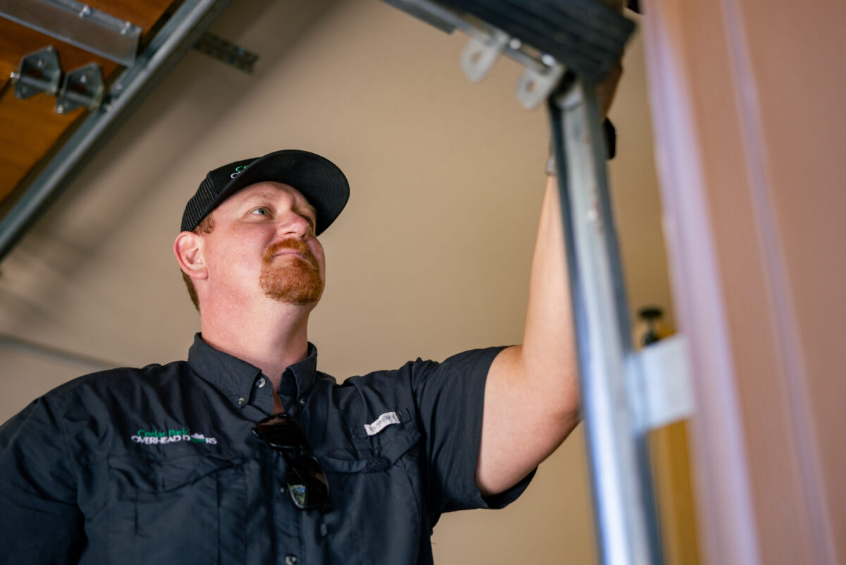 garage door tune up worker using black shirt close up
