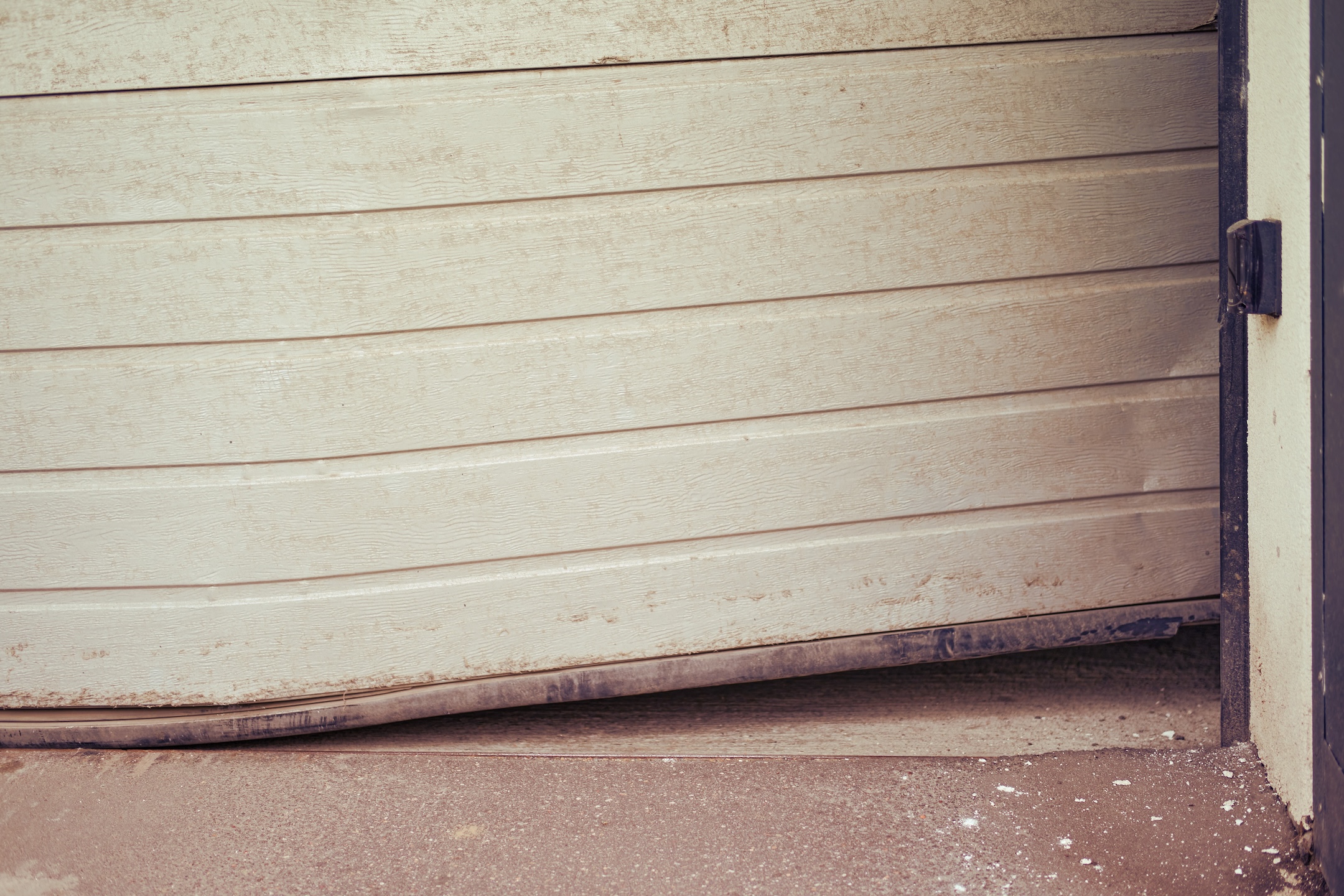 Damaged bent door that rises when opening a lift garage